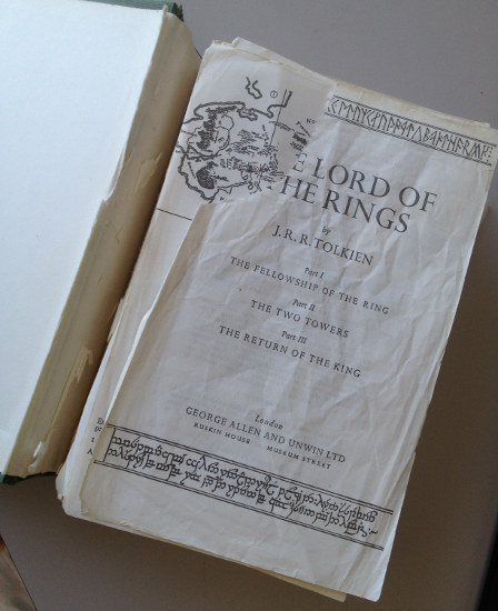 Poor abused hardcover of Lord of the Rings with ripped pages coming away from the book spine